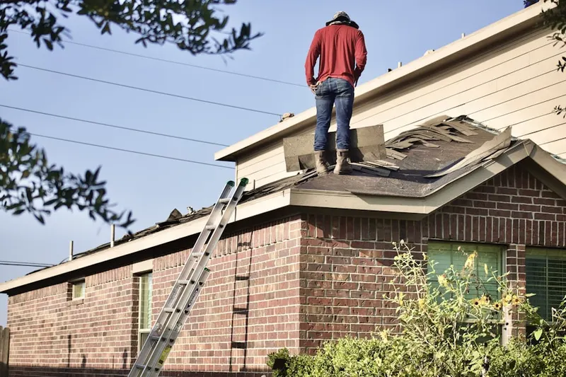Professional roofer working on a residential roof in Pine Brook